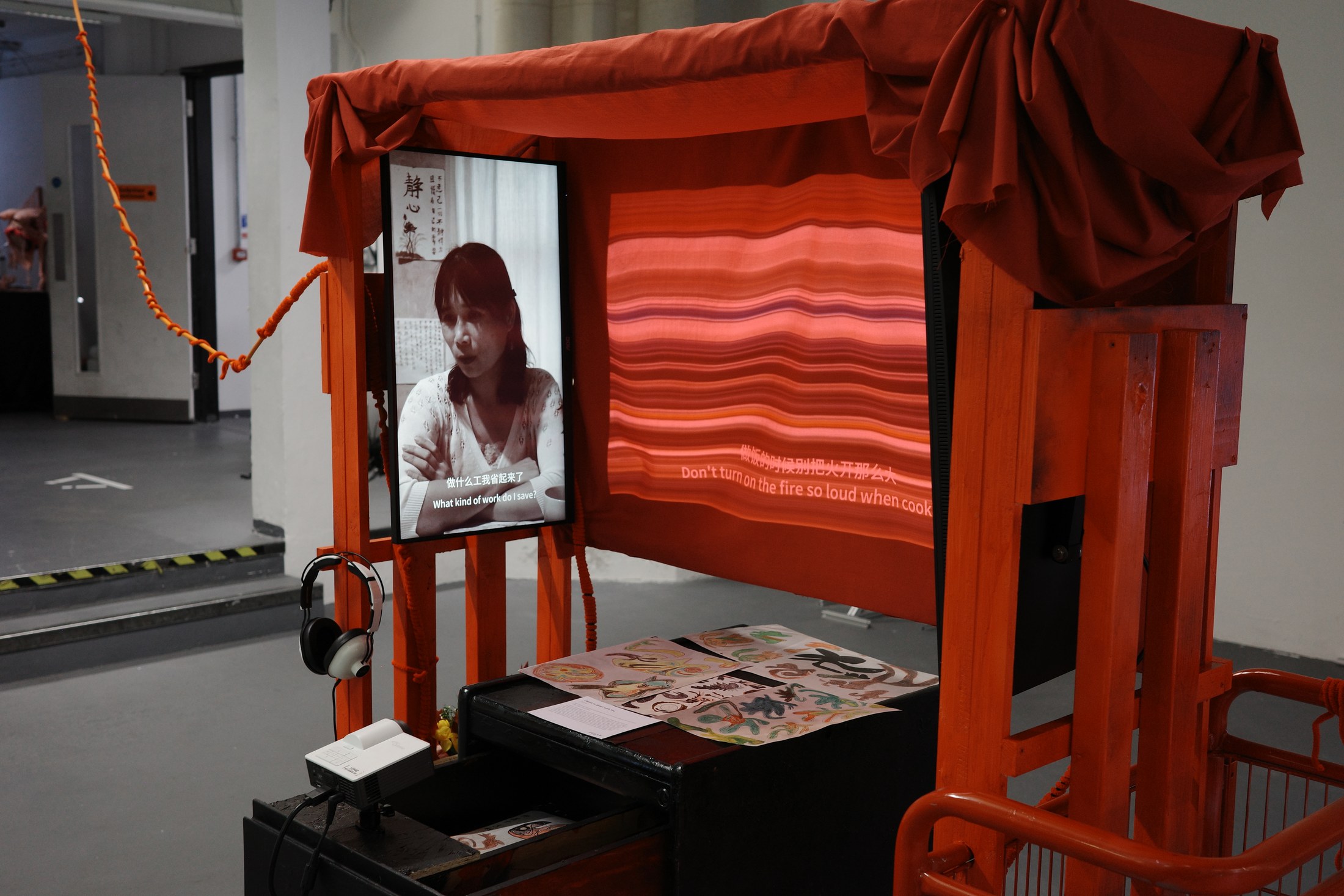 Full frontal view of the red pushable cart installation with three-channel video and projection